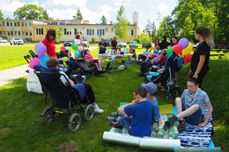 Niepełnosprawne osoby na wózkacj z kolorowymi balonami